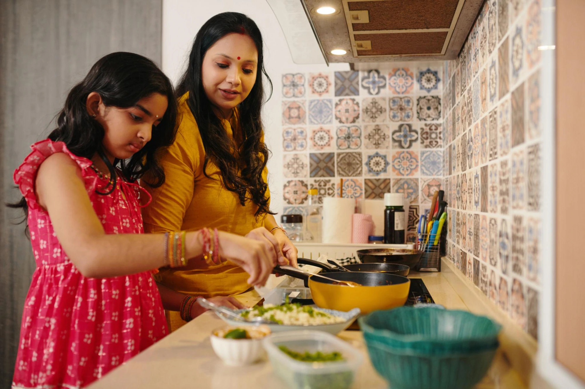 Mother and daughter cooking together in the kitchen