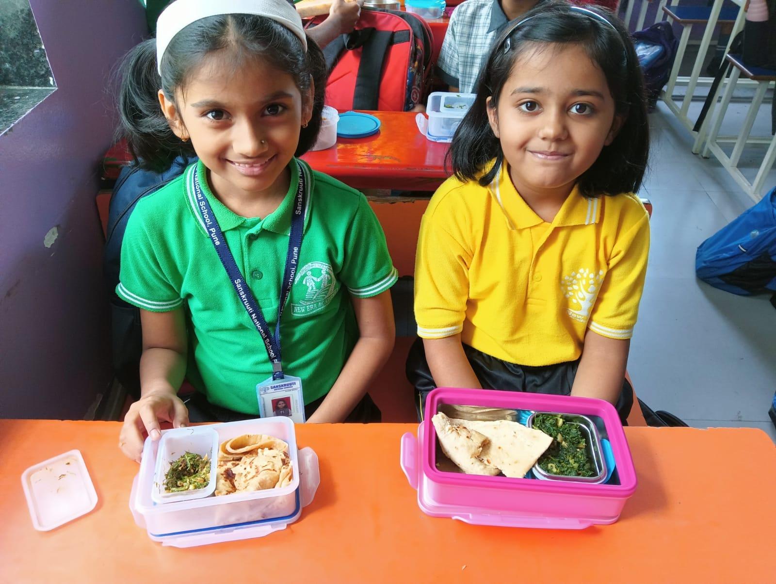 School friends opening their home-packed vegetarian tiffins